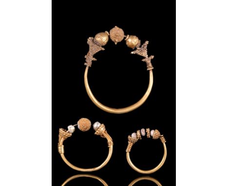 Ca. 100-300 AD. A substantial pair of Ancient Roman gold earrings featuring a large convex shaped bead which looks like a ves