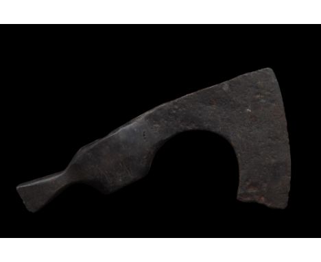 Ca. 900-1100 AD. A forged-iron axe head of a sizeable form with a long neck, a verticle blade with flared tips, and a wide so