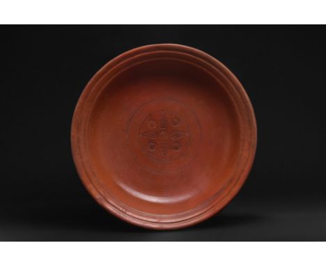 Ca. 300-400 AD. A wheel-thrown redware pottery dish of a squat form that rests atop a flat base. The vessel features broad wa