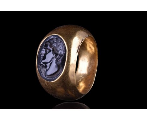 Ca. 300 BC. A beautiful gold ring with a hollow circular band and an oval black gemstone with an intaglio depicting a left-fa