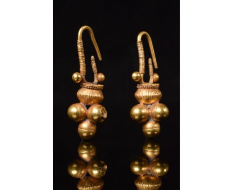 Ca. 100-300 AD. A substantial pair of Ancient Roman gold earrings featuring a large convex shaped bead which looks like a ves