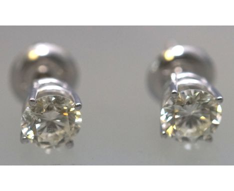 A white metal pair of single stone studs. Each set with a round brilliant cut diamond measuring approximately 5.40mm. Estimat