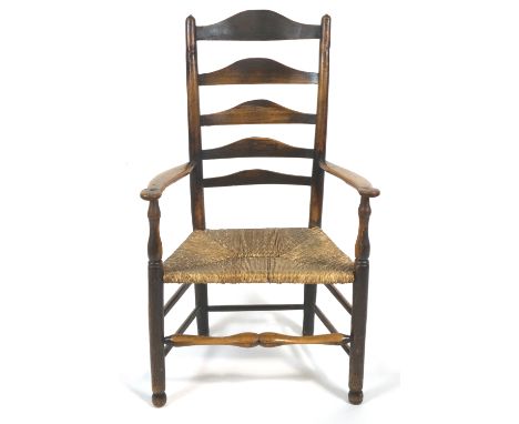 An oak ladder back armchair with rush seat, 19th century, with turned baluster front legs and front stretcher, 114cm high x 8