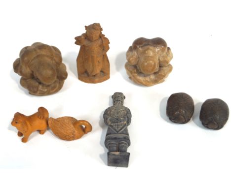 A group of eight Asian figures, comprising two wood netsuke of a dog and goose, four of men curled up into balls, a terracott