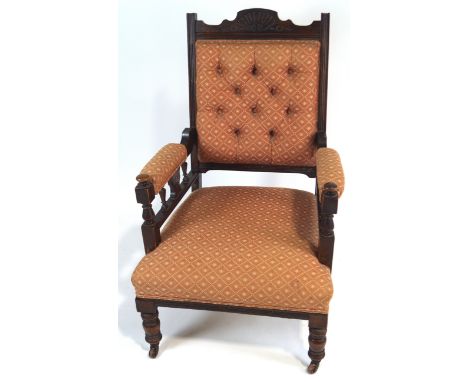 A late Victorian mahogany arm chair with button back, on turned legs with ceramic casters, overall 103cm high x 65cm wide x 6