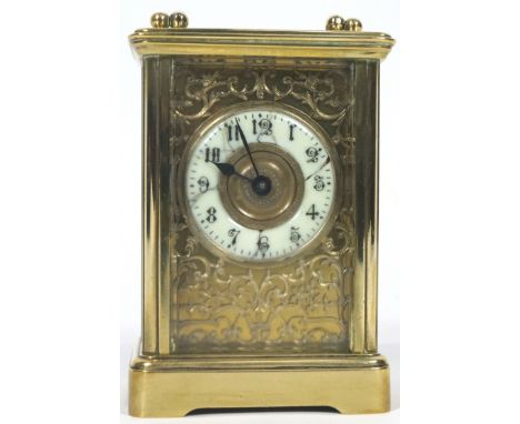 A Continental brass carriage clock, with cream enamel dial surrounded by elaborate scrolling filigree fretwork of scrolling f