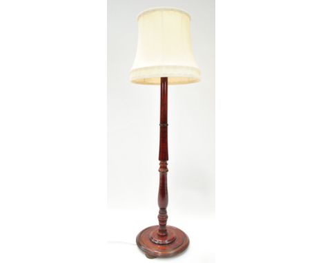 A mahogany turned standard lamp, on round stained pine base, on bun feet,140cm high