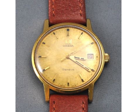 A gold plated Omega Geneve wristwatch. Circular gold dial with baton markings and date feature. Manual wind movement. Stainle