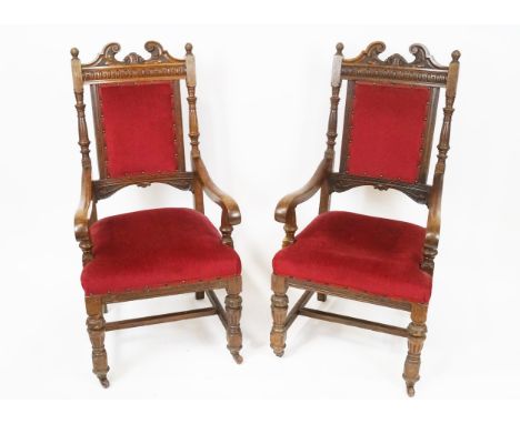 A pair of Victorian oak armchairs, with broken swan  neck pediment, above a lozenge carved frieze, the upholstered back flank