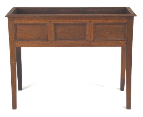 An early 20th century oak plant stand, of rectangular form, with three panel division decoration, raised on plain square legs