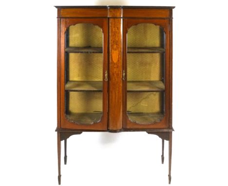 An Edwardian mahogany display cabinet with two glazed doors flanking a marquetry panel on square tapering legs with spade fee