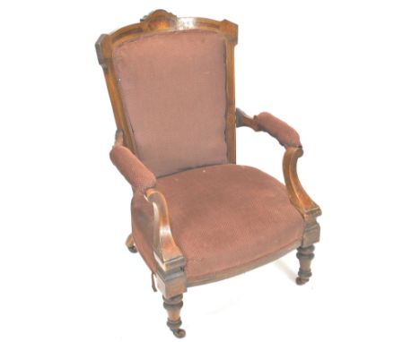 A Victorian walnut and marquetry framed armchair with upholstered back, seat and arm rests on turned tapering legs and cerami