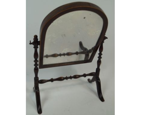 A mahogany framed arch topped swing mirror, of small proportions, on bobbin turned supports and stretcher, raised on splayed 