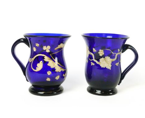 A 19th century blue glass mug painted in enamels and gilt, with loop handle and pontil mark, 11cm high, together with another