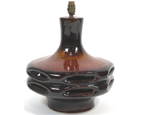A large Studio pottery flambe glazed lamp base, circa 1970, the octagonal section base pierced with ovals, enriched in dark r