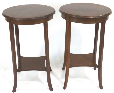 A pair of Edwardian occasional tables, of rounded form, the tops with cross banded edges and two lines of stringing, over a s