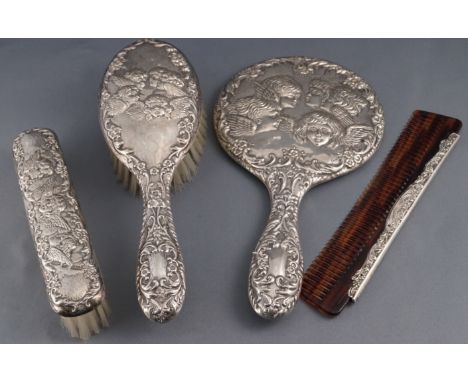 A ladies loaded silver dressing set, comprising : a hand mirror, two brushes and a comb, decorated with the Reynold's Angel H