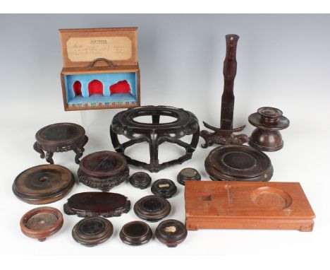 A collection of sixteen Chinese hardwood stands, late 19th century and later, including an oval stand with carved apron and s
