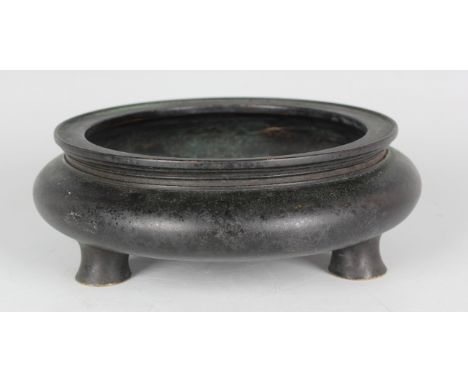 A Chinese dark brown patinated bronze censer of squat circular form on short tripod feet, cast seal mark to base, weight 1405