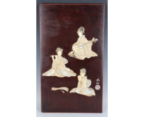 A Japanese inlaid lacquer rectangular panel, Meiji/Taisho period, inlaid in ivory, bone and mother-of-pearl with three seated