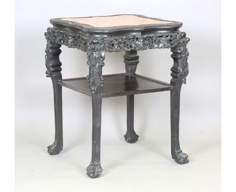A Chinese hardwood stand, late 19th century, the shaped square top inset with a rouge marble panel within a carved blossoming