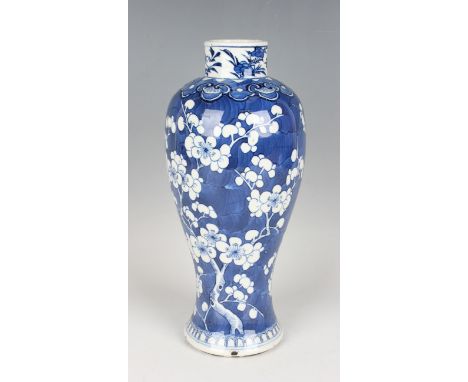 A Chinese blue and white porcelain vase, mark of Kangxi but late 19th century, of baluster form, painted with prunus branches