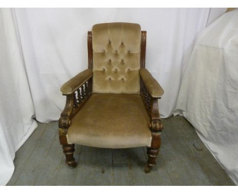 A Victorian mahogany upholstered button back armchair with galleried sides on four turned legs