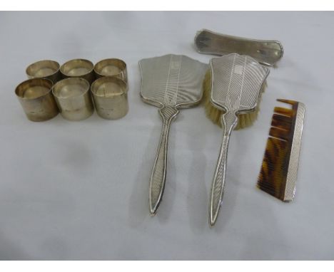 A quantity of silver to include six napkin rings and a brush, hand mirror and comb set with silver fittings