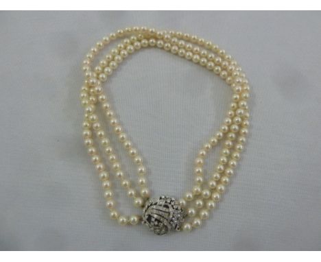 A three strand cultured pearl necklace with 18ct white gold and diamond clasp