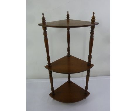 A mahogany three tier wall hanging corner shelf