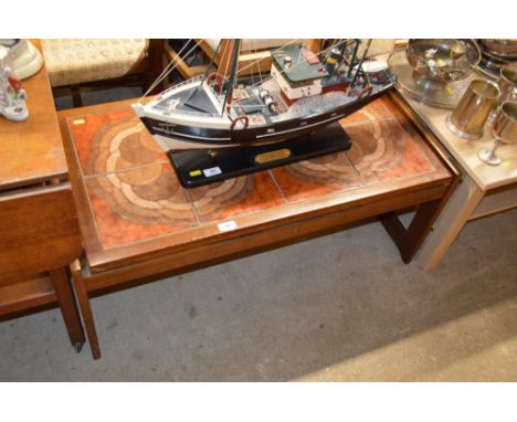 A teak and tile topped coffee table 