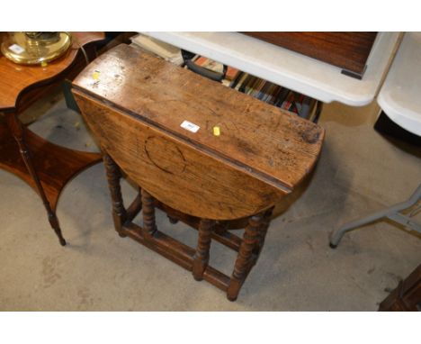 A small oak gate leg table raised on bobbin turned supports 