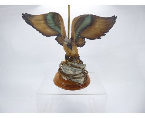 A Brass and Ceramic Lamp Base, depicting an eagle with wings held aloft, on circular base, approx 32 cms.