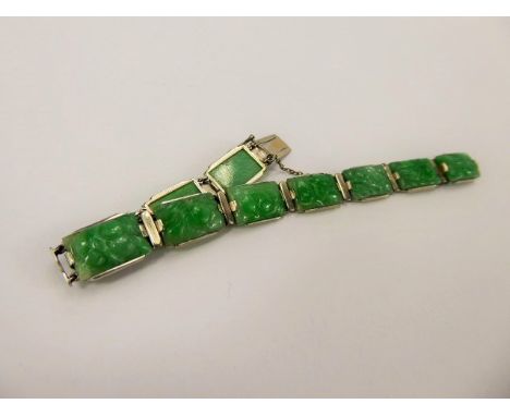 A Chinese White Metal Bright Green Jade Bracelet, the bracelet having ten carved segments approx 12 x 9 mm, approx length 16 