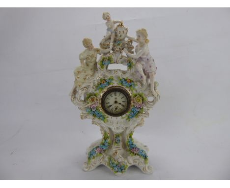 An Antique Meissen-Style Figural Mantel Clock, with delicate foliate decoration in relief and figural group to clock mount, a