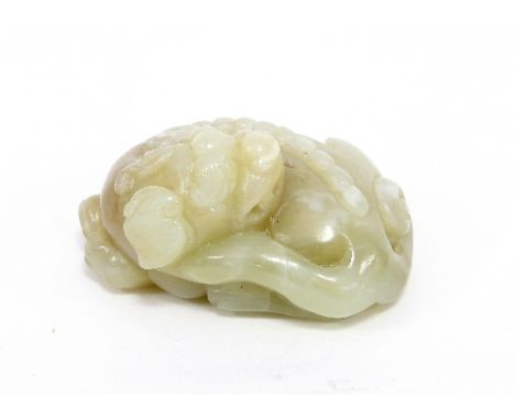 A celadon jade carving of a sleeping lion, 6.5cm long