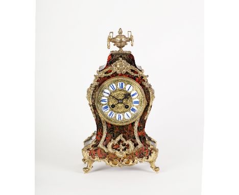 A 19th Century tortoiseshell and brass boulle type eight-day mantel clock, the case with gilt metal urn finial and mask head 