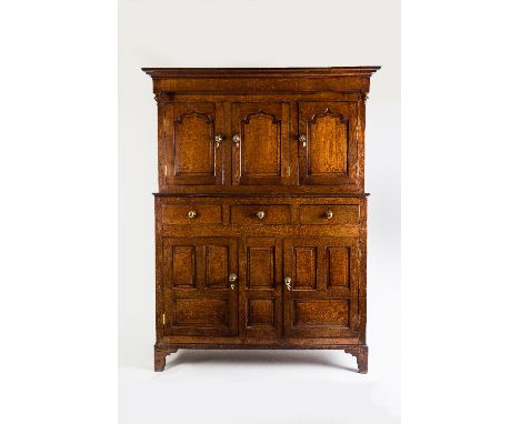 A Welsh oak duodarn, circa 1800, the moulded cornice above three recessed fielded panel doors above three short drawers and t