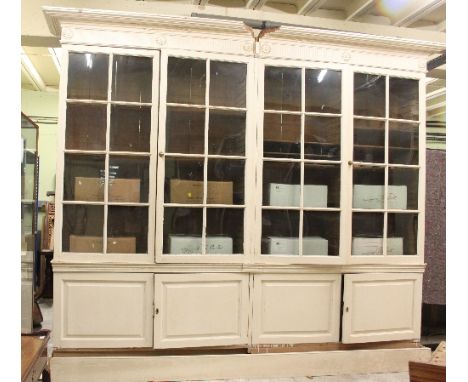 A very large 19th Century painted pine library bookcase, with moulded cornice above fluted frieze and four glass panelled doo