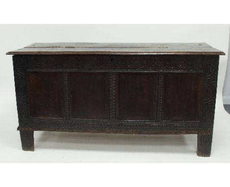 An 18th Century oak coffer, the hinged lid above a quadruple panel front on carved supports, 160cm wide, (alterations)