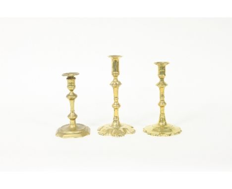 A George III brass petal based candlestick, 21cm high, another similar and a George I brass candlestick, 18cm high