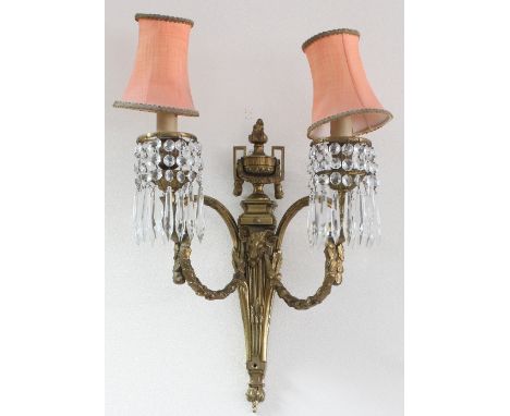 A gilt brass two-branch wall light of Empire design, with urn finial and rams mask head supports to the scrolling branches, 4