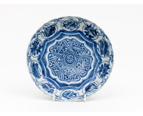 A Chinese blue and white shallow dish, Kangxi, painted in underglaze blue with geometric designs within a border of auspiciou