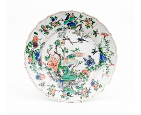 A Chinese famille verte dish, Kangxi, circa 17th Century, decorated in the centre with exotic birds and flowering bushes, the