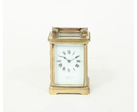 A gilt brass carriage clock, the case with swing handle fitted a rectangular white enamel dial with Roman numerals, inscribed