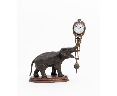 A Junghans mystery or swinger clock of elephant form the patinated spelter elephant with raised trunk suspending a pendulum s
