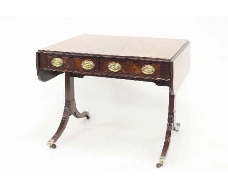 A Regency mahogany sofa table fitted with two drawers each with two brass swing handles, the top and front with ebony banding