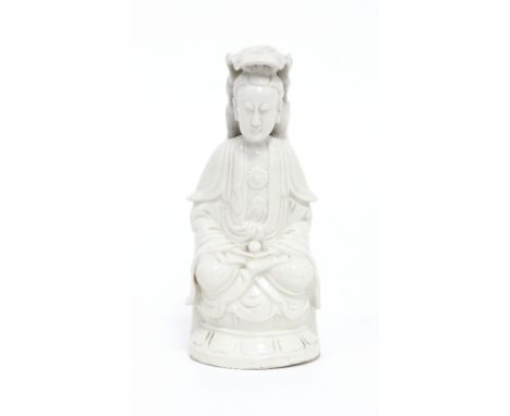 A Chinese blanc-de-chine figure of Guanyin, Kangxi, the figure seated cross legged on a lotus, 17.5cm high Condition Report: 