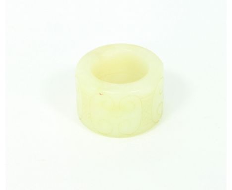 A celadon jade ring carved with scrollwork, 3.25cm diameter