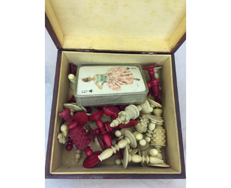 A late 19th century carved and red stained ivory chess set, a vintage packet of playing cards, circa 1960's, both contained i